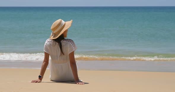 Woman sit on beach enjoy sea view alt