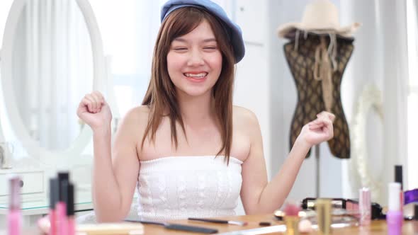 Portrait of young asian woman review cosmetics product fan following channel