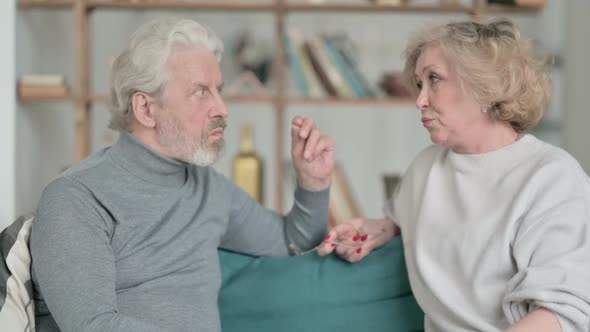 Old Couple Having Conversation While Sitting on Sofa alt