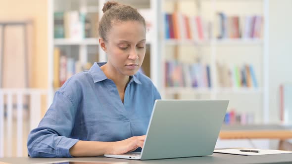 Loss, African Woman Reacting To Failure on Laptop in Library alt