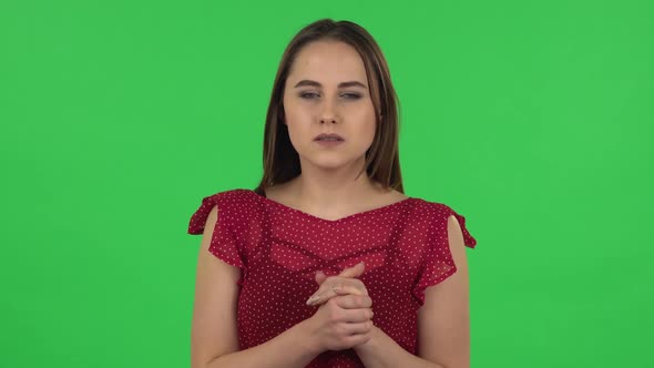 Portrait of Tender Girl in Red Dress Is Standing Worrying in Expectation Then Smiles with Relief alt