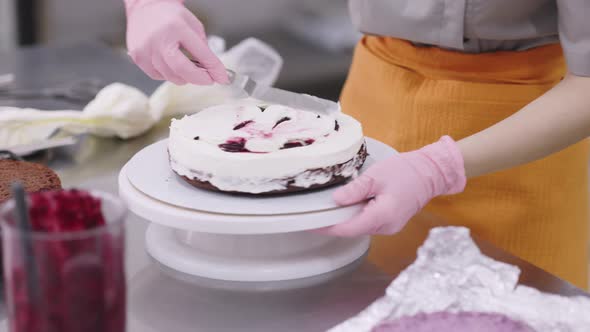 A Bright Pastry Chef Girl is Engaged in the Preparation of a Cake