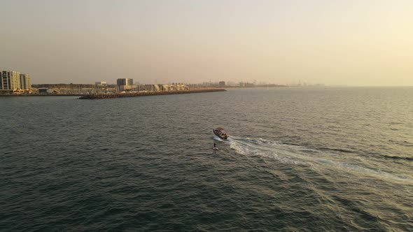 Air Survey Wakeboarder Wakeboarding After a Boat on Sunset View From Above