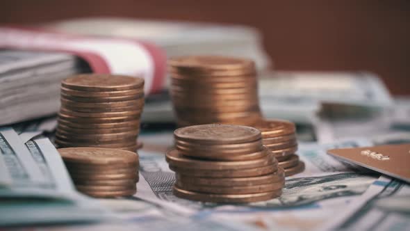 Columns of Coins are Spinning Against the Background of One Hundred Dollar Bills alt
