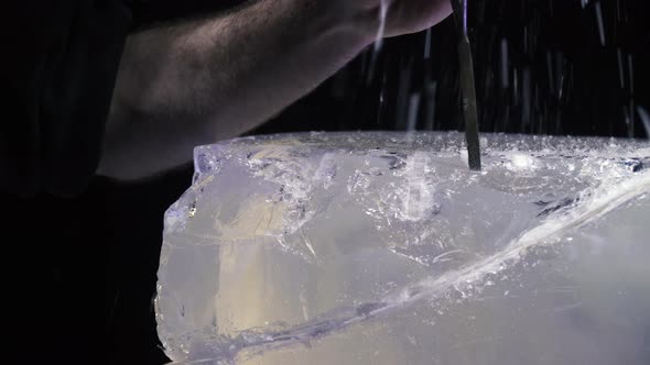Artist Using Tools to Create an Ice Sculpture Breaking Off Pieces of Ice alt