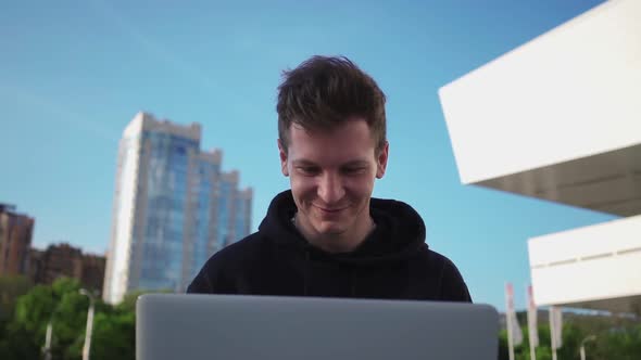 Happy Guy is Using Laptop and Smiling While Enjoying Watching Videos on Internet alt
