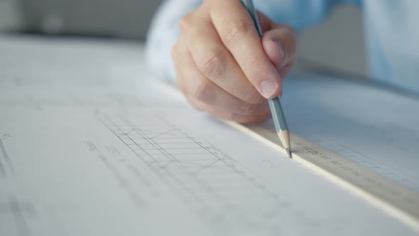 Architect's hands drawing a plan alt