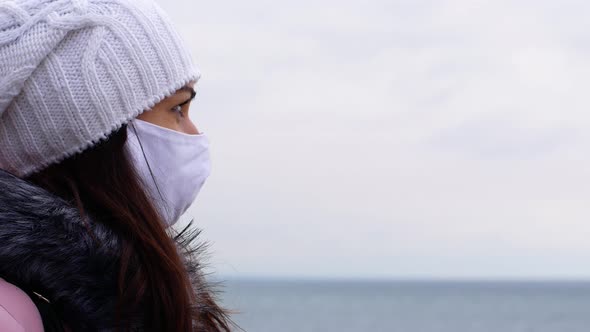 Front view of a woman with long dark hair in a face mask from air pollution Covid19 alt
