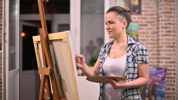 woman makes a picture in her creative studio late at night alt