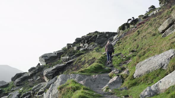 Low Angle View Of A European Woman Climbing On The Valley Of Rocks In Lynton, United Kingdom - camer alt