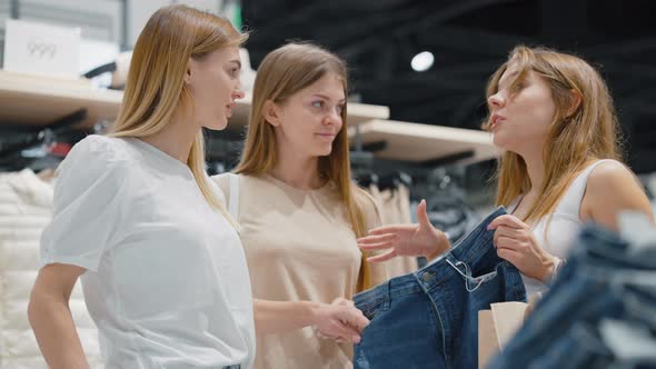 Friends Choosing Pair of Jeans at Store Together alt