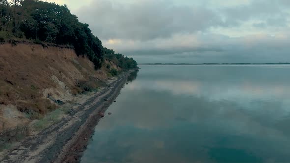 Aerial view of a beach with quiet water alt