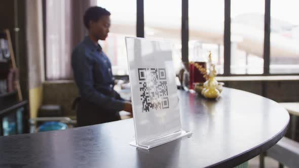Hand of customer using smartphone to read qr code on the bar at a cafe alt