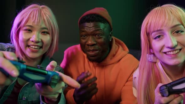 Three Joyful Casually Dressed Multiracial People in Their 20s Playing Together alt