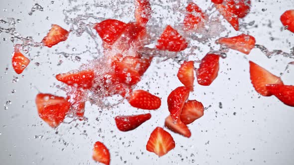 Super Slow Motion Shot of Fresh Strawberries and Water Side Collision on White at 1000Fps alt