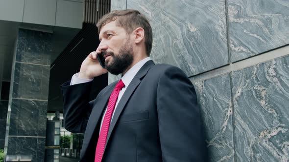 A Man is Talking on a Cell Phone in the Street alt