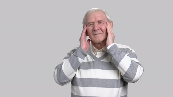 Senior Man with Headache, Grey Background. alt