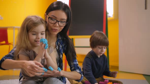 Preschool Teacher and Girl Having Fun with Toys alt