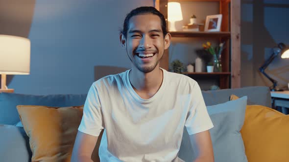 Happy young freelance asian man looking at camera smiling and cheerful relax on video call online.