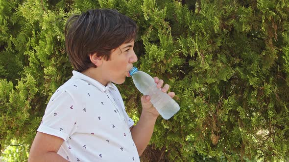 Teenage Boy Drinks Water From Plastic Bottle alt