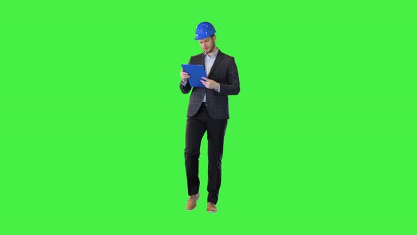 Concentrated Businessman Investor or Building Owner Read Documents Walking Wear Construction Hardhat alt