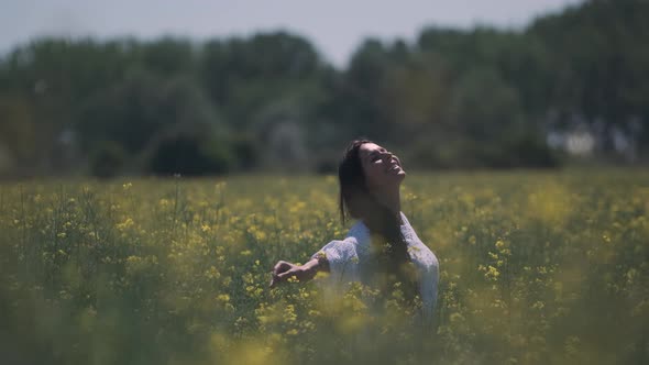 Pretty young woman in the rapeseed field