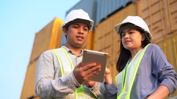 Two foreman checking and control loading containers box from cargo