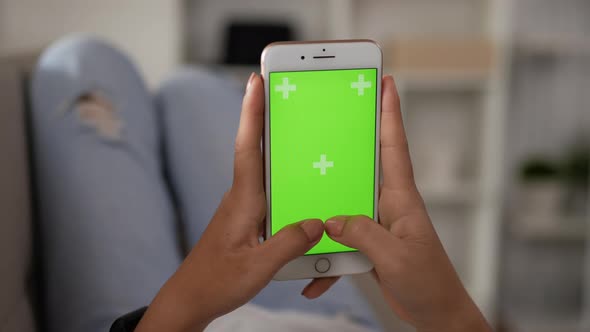 Closeup vertical of hand woman typing smartphone with green screen alt