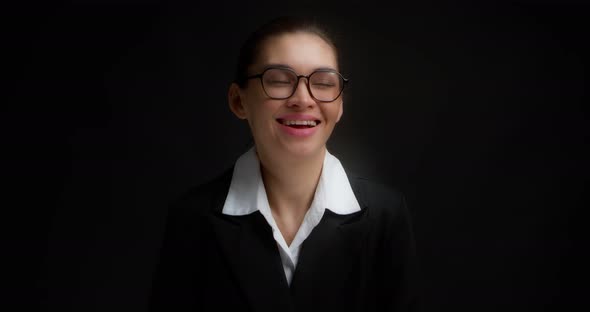 Positive Business Woman Laughs at the Camera Standing on an Black Background