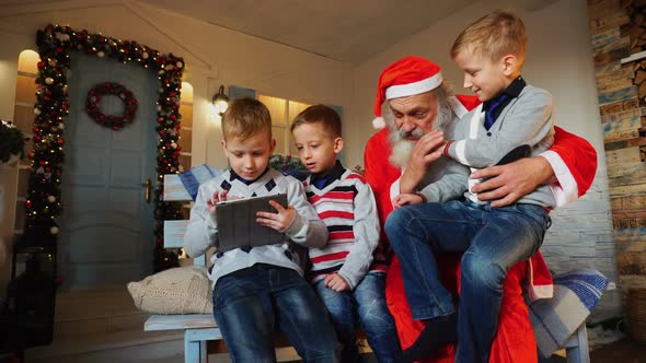 Little Boys  with Santa Claus Playing with Tablet.