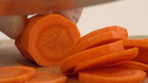 The cook cuts carrots on a cutting board. alt