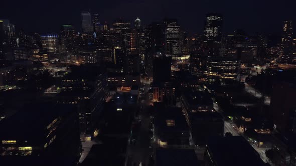 Helicopter Pan Up To Reveal Skyscraper Buildings In City At Night alt