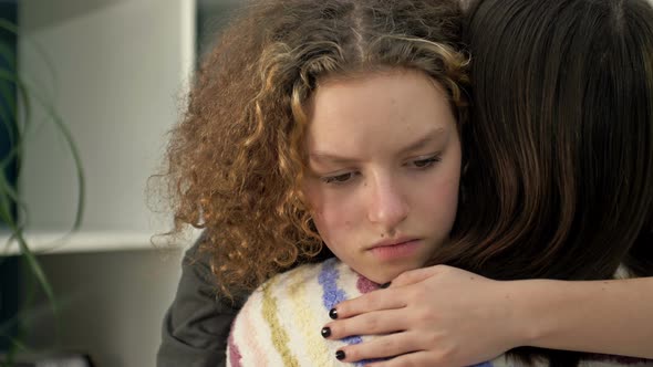 Sad Teenage Girl Hugging Her Mom or Friend