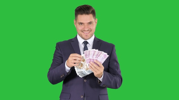 Business man showing euro banknotes smiling on a Green alt