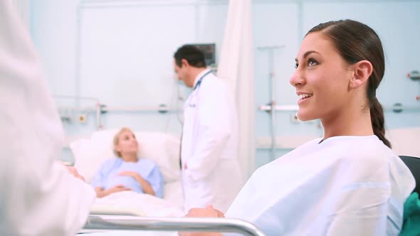 Obstetrician talking to a smiling patient lying in a bed alt