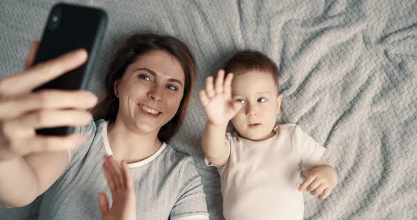 Mother Taking Selfie with Baby Boy Using Mobile Phone alt