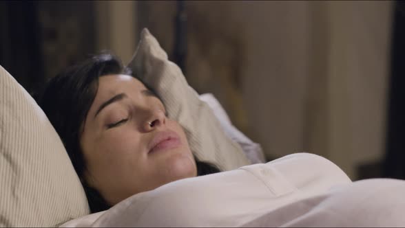 Woman Lying on Bed and Giving Birth at Home alt