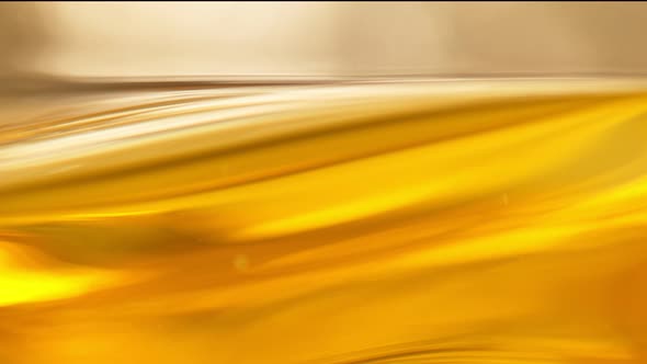 Super Slow Motion Shot of Moving Oil Waves on Golden Background at 1000Fps alt