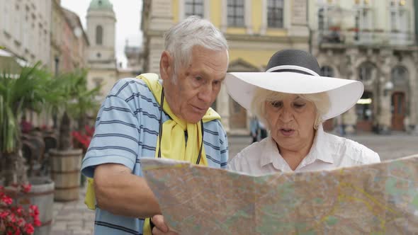 Senior Two Tourists Having Discussion About Planning Tourist Route in Lviv alt
