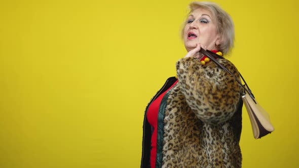 Confident Senior Wealthy Woman Hanging Luxurious Expensive Purse on Shoulder and Leaving Yellow alt