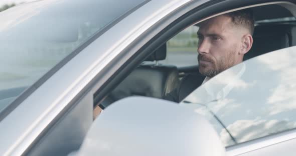 Closeup Portrait of Successful Businessman is riding his luxury elegant Car. alt