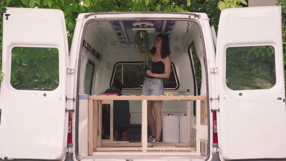 Man And Woman Decorating Interior Of A Camper Van. static shot alt