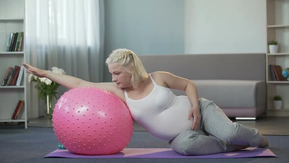 Pregnant Girl Doing Exercises at Home, Removing Tension From Her Tired Body alt