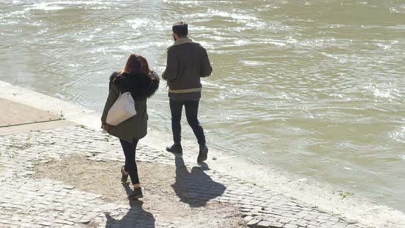 young couple walk on the embankment of the river on a sunny day- slow motion