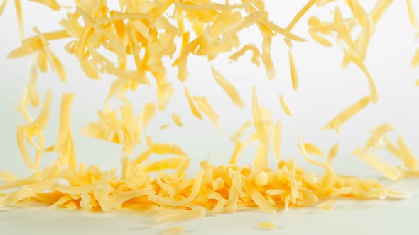Super Slow Motion Shot of Grated Cheddar Cheese Falling on White Background at 1000 Fps alt