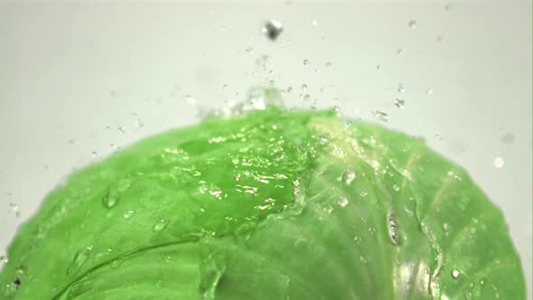 Super Slow Motion on the Fork of Cabbage on a White Background Drop Drops of Water alt