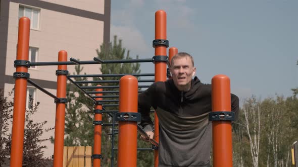 Man Exercising on Parallel Bars in an Outdoor Gym alt