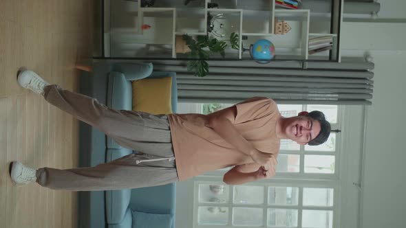 Full Body Of Asian Man Dancing While Shooting Video Content For Social Networks At Home alt