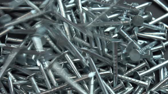 Metal Steel Nails for Construction Work Falling on a Rotating Surface Hobnails are Spinning Close Up alt