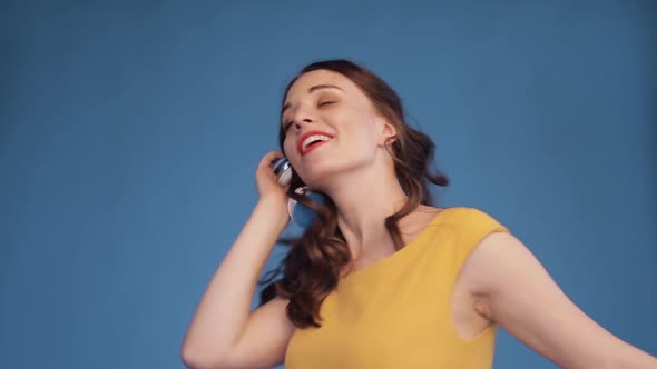 Jovial Young Woman Dancing While Listening To Music in Headphones